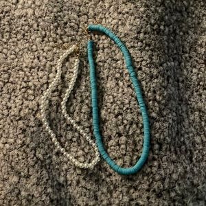 White pearl necklace and a teal necklace